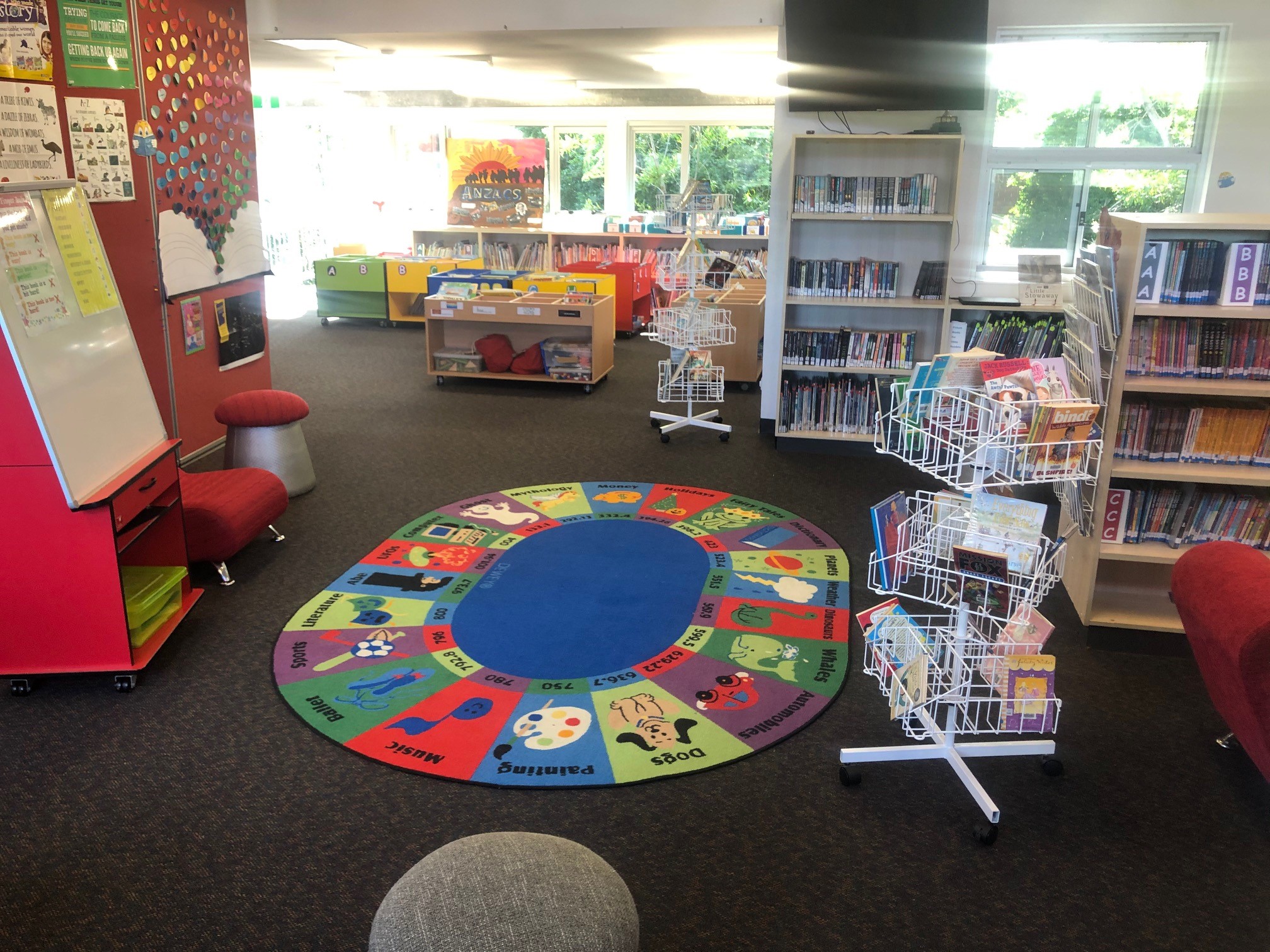 interior photo of library - colourful mat on the floor surrounded by bookshelves