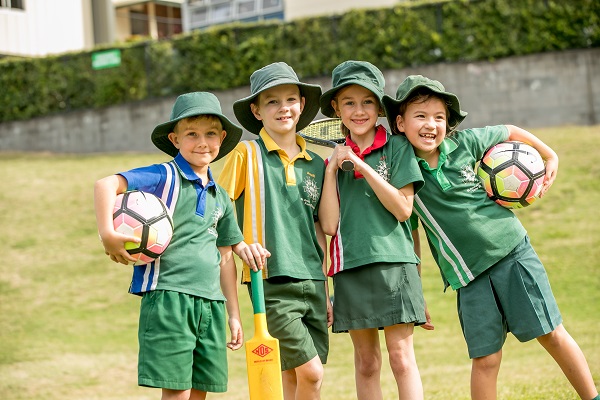 four boys holding tennis racquets and soccer balls